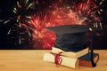 Image of graduation black hat over old books next to graduation on wooden desk. Education and back to school concept. Royalty Free Stock Photo