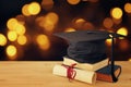 Image of graduation black hat over old books next to graduation on wooden desk. Education and back to school concept. Royalty Free Stock Photo