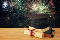 Image of graduation black hat over old books next to graduation on wooden desk. Education and back to school concept. Royalty Free Stock Photo