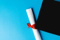 Image of graduation hat and diploma on blue surface Royalty Free Stock Photo
