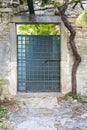 Image of a green entrance door to a residential building with an antique faÃÂ§ade