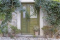 Image of a green entrance door to a residential building with an antique faÃÂ§ade