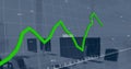 Image of green graph processing data over computers on desks at office