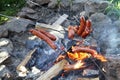 Grilling sausages on an open fire in a countryside