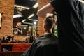 Image of hairdresser making a haircut for a young man in a barber shop Royalty Free Stock Photo