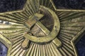 Image of a hammer and sickle on a pentagonal star of the USSR period. Metal bas-relief on marble close-up. Berel Dismantled in Royalty Free Stock Photo