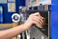 Image of hand inserting coin into washing machine in self service laundry room Royalty Free Stock Photo