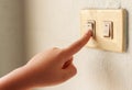 An image hand people lowering the power on their utilities turn off light switch saving energy of the home interior Royalty Free Stock Photo