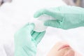Image of hands in green gloves holding a spray bottle and cotton pads. Skin care concept Royalty Free Stock Photo