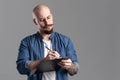 Image of handsome balded beard with musctache man wearing casual clothes holding clipboard and pen isolated over gray