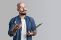 Image of handsome balded with musctache and beard man wearing casual clothes holding clipboard isolated over white