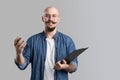 Image of handsome balded with musctache and beard man wearing casual clothes holding clipboard isolated over white