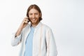 Image of handsome bearded man talking on mobile phone and smiling, casually laughing during cellphone call, cellular Royalty Free Stock Photo