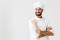 Image of handsome chief man in cook uniform smiling while holding wooden kitchen utensils Royalty Free Stock Photo