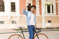 Emotional young african guy on the street outdoors walking with bicycle Royalty Free Stock Photo