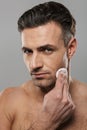 Handsome mature man take care of his skin. Royalty Free Stock Photo