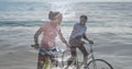 Image of happy african american couple with bikes over seascape