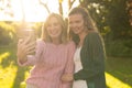 Image of happy caucasian mother and adult daughter taking selfie in autumn garden Royalty Free Stock Photo