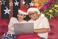 Happy couple using a laptop at Christmas time Royalty Free Stock Photo