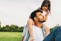 Image of happy cute little girl playing with father in the park during the sunset. Handsome dad is spending time with his little Royalty Free Stock Photo