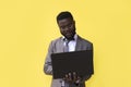 Image of happy excited young african man isolated over yellow background using laptop computer Royalty Free Stock Photo