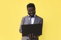 Image of happy excited young african man isolated over yellow background using laptop computer Royalty Free Stock Photo