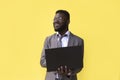 Image of happy excited young african man isolated over yellow background using laptop computer Royalty Free Stock Photo
