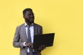 Image of happy excited young african man isolated over yellow background using laptop computer Royalty Free Stock Photo