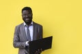 Image of happy excited young african man isolated over yellow background using laptop computer Royalty Free Stock Photo