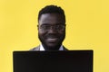 Image of happy excited young african man isolated over yellow background using laptop computer Royalty Free Stock Photo