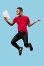 Image of happy excited young african man jumping isolated over yellow background using laptop Royalty Free Stock Photo