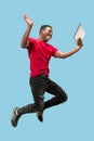 Image of happy excited young african man jumping isolated over yellow background using laptop Royalty Free Stock Photo