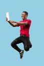 Image of happy excited young african man jumping isolated over yellow background using laptop Royalty Free Stock Photo