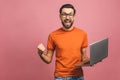 Image of happy excited young man posing isolated over pink background wall using laptop computer make winner gesture Royalty Free Stock Photo