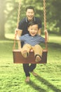 Happy father and his son playing with swing Royalty Free Stock Photo