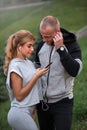 Image of happy fitness sport loving couple friends in park outdoors listening music with earphones Royalty Free Stock Photo