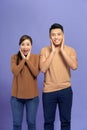 Image of happy friends loving couple standing isolated over purple background screaming looking camera Royalty Free Stock Photo