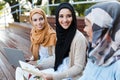 Image of happy friends muslim sisters women sitting outdoors Royalty Free Stock Photo