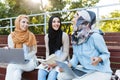 Image of happy friends muslim sisters women sitting