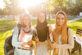 Image of happy friends muslim sisters women walking outdoors holding books Royalty Free Stock Photo