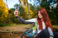 Image of happy girl photographing herself in autumn forest Royalty Free Stock Photo