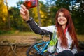 Image of happy girl photographing herself in autumn forest Royalty Free Stock Photo