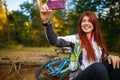 Image of happy girl photographing herself in autumn forest Royalty Free Stock Photo