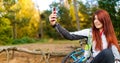 Image of happy girl photographing herself in autumn forest Royalty Free Stock Photo