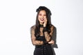 Image of happy good-looking asian woman in gothic dress and black wreath, laughing at halloween party, standing over