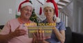 Image of happy holidays and happy new year text over senior caucasian couple wearing santa hats Royalty Free Stock Photo