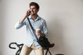 Image of happy man holding coffee and talking on cellphone by bicycle Royalty Free Stock Photo