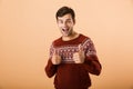 Image of happy man 20s with bristle wearing knitted sweater show Royalty Free Stock Photo