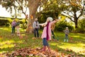 Image of happy multi generation caucasian family having fun with leaves in autumn garden Royalty Free Stock Photo
