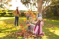 Image of happy multi generation caucasian family having fun with leaves in autumn garden Royalty Free Stock Photo